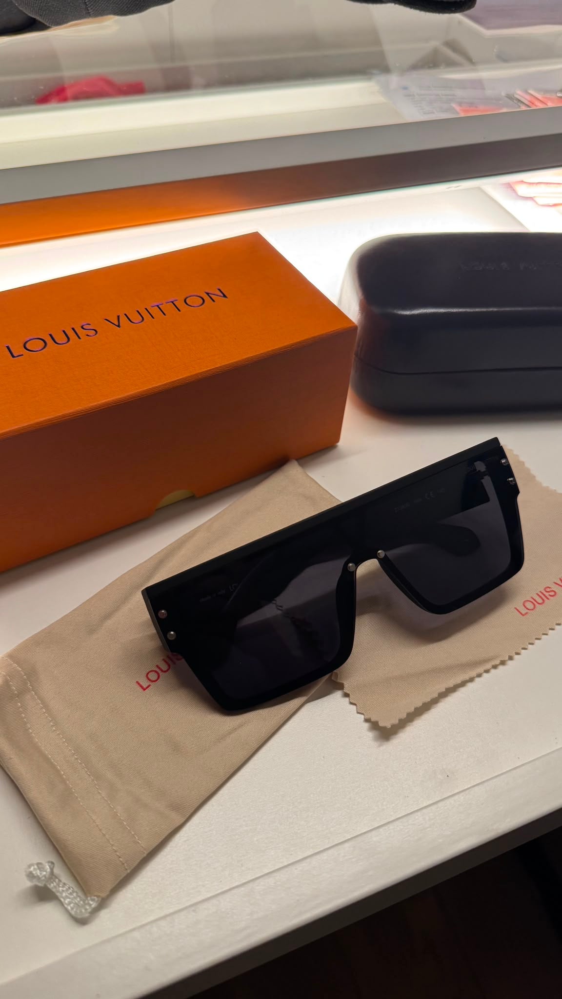 Oversized black shield sunglasses with hard case and orange presentation box