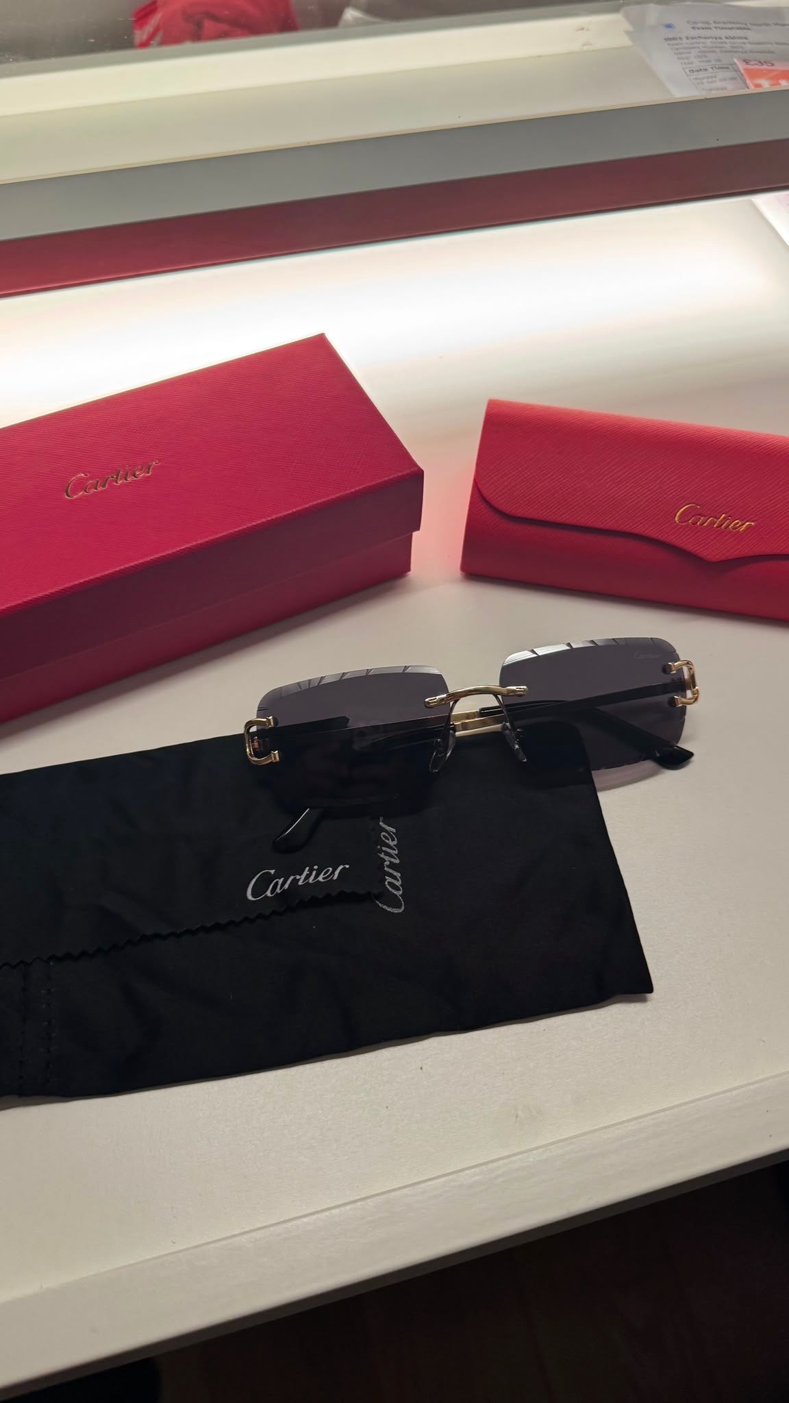 Rimless rectangular sunglasses on cloth with presentation box and case