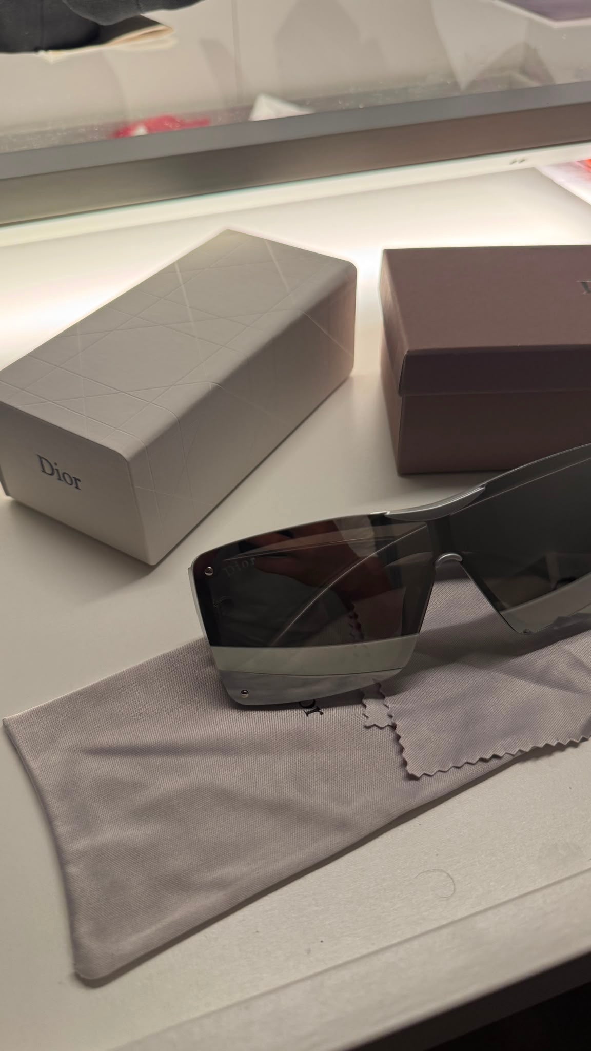 Silver statement sunglasses on cloth with presentation boxes